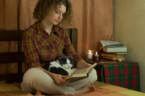 Kız Yatakta Açık Bir Kitap Okuma Bir Kedi — Stok fotoğraf