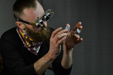 Steampunk adamı gözlük takıyor ve robotu elinde tutuyor