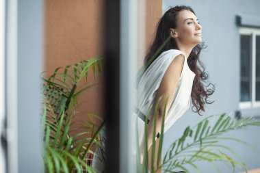 güzel kadın balkonda duran korkuluk üzerine eğilerek 