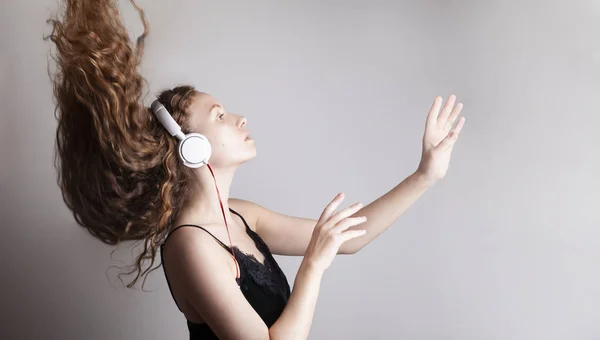 Hermosa Mujer Joven Escuchando Música Con Auriculares Frente Pared Blanca — Foto de Stock