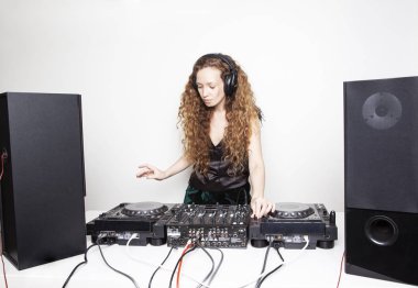 güzel kızıl saçlı kadın djing beyaz duvar önünde 