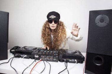 Kıvırcık saçlı Genç Dj oynarken müzik ışık arka plan üzerinde portresi