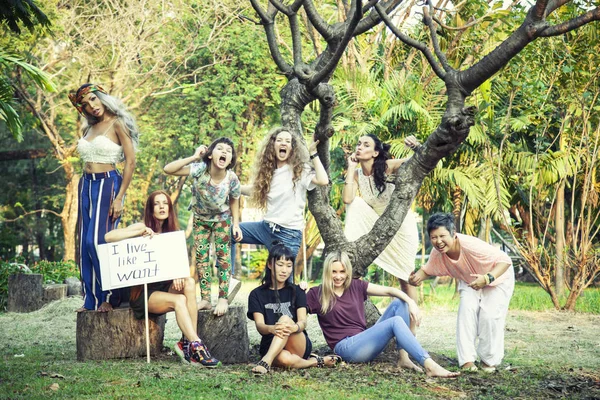 women in the park with a poster \