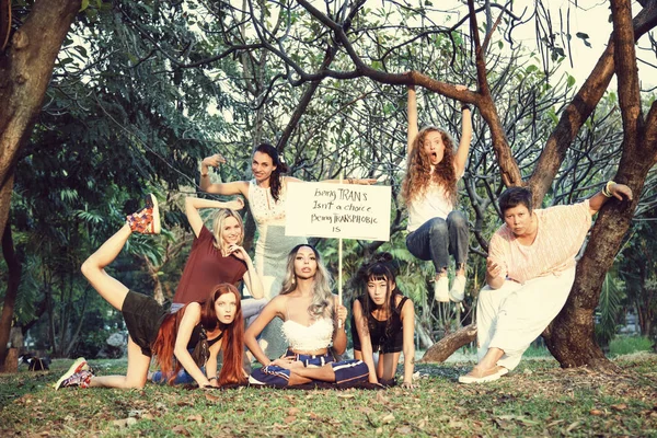 group of women posing with feminist slogan poster in natural scene