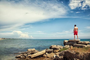 Kumsalda ve denizde genç bir adam