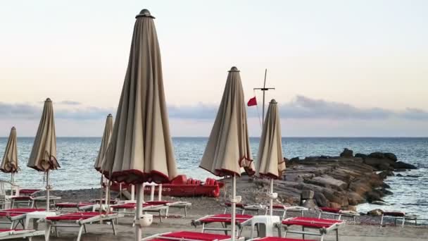 Italienischer Strand mit roter Flagge und Sonnenschirmen