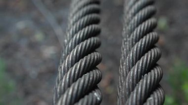 Aşağıdan yukarıya atılan kalın bükülmüş metal kabloları kapatın. Çelik halatları detaylıca gösteren yavaş çekim tavası