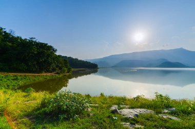 Göl ve dağ ile gün batımı manzara