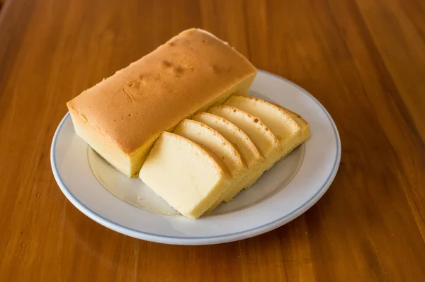 Butter cake on white dish with wooden background — Stock Photo, Image