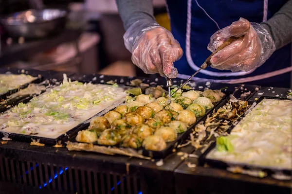 料理人は日本のたこ焼き、ストリートフードを取ります — ストック写真