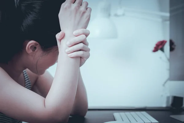 depressed women sitting in front computer after hard working alone sadness emotional and wrist arm pain. office syndrome healthcare and medicine concept