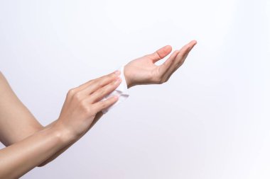 Kadın ellerini beyaz yumuşak mendil kağıdıyla temizliyor. Beyaz bir arka planda izole edilmiş