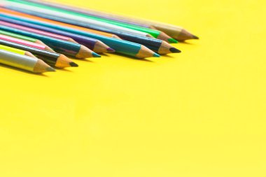 Ekip çalışması kavramı. sarı arka plan üzerinde renkli kalem grubu