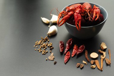 Kerevit kırmızısı, siyah arka planda kızarması için otlu bebek ıstakozu.