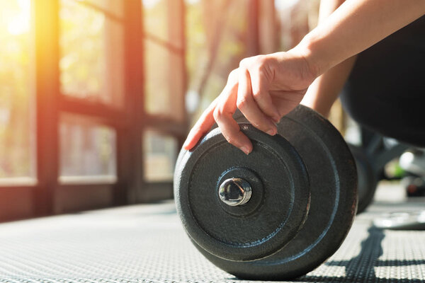 Женщины вручную устанавливают стальной гантель в тренажерном зале
