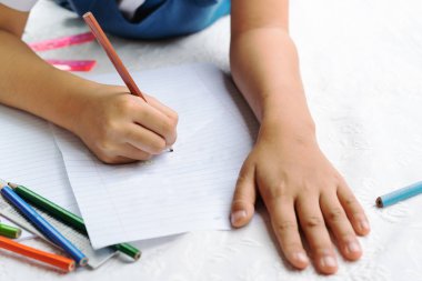sevimli küçük kız yazma-kitaplar için yazıyor. Dersler karar. kız resmi çizim uzan