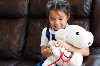 küçük kız gülümseyerek ve Doktor stetoskop ile oynayan. Çocuk ve sağlık kavramı.