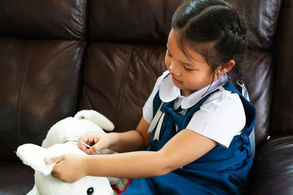 küçük kız gülümseyerek ve Doktor stetoskop ile oynayan. Çocuk ve sağlık kavramı.