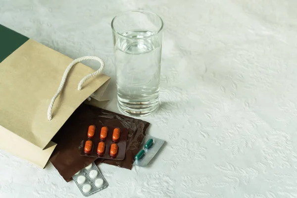 医薬品付き病院の医師からの処方注文 白い背景に水のガラスと慢性患者のためのプラスチックジップバッグの薬 — ストック写真