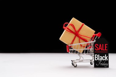 Kara Cuma indirimi, alışveriş arabası ve fiyat etiketli hediye kutusu.