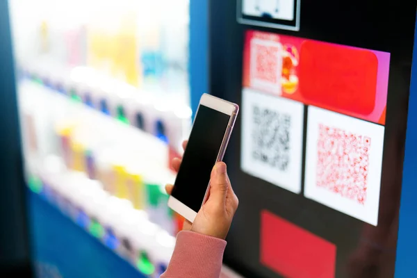 QR kodu ödemesi, online alışveriş, nakitsiz teknoloji konsepti. Satıcının ödemesi için akıllı telefonu kadınlar tutuyor.