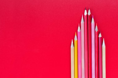 Ekip çalışması kavramı. Grup kırmızı arka plan üzerinde renkli kalem