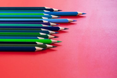 Ekip çalışması kavramı. Grup kırmızı arka plan üzerinde renkli kalem