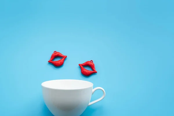 情人节的概念 红色亲吻与白色咖啡杯在蓝色背景 — 图库照片