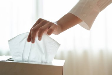 Kadınlar mendil kutusundan peçete / mendil topluyor.