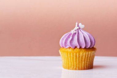 Mutlu Anneler Günü, pembe arka plan üzerinde mor krem küçük beyaz kalp ile sevimli cupcake