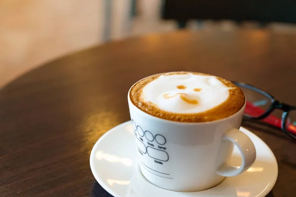 Горячий кофе на деревянном столе с очками — стоковое фото