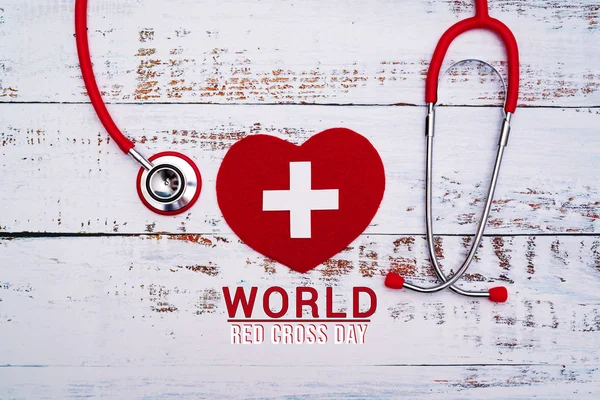 World Red Cross day. Red heart with Stethoscope on wooden table background