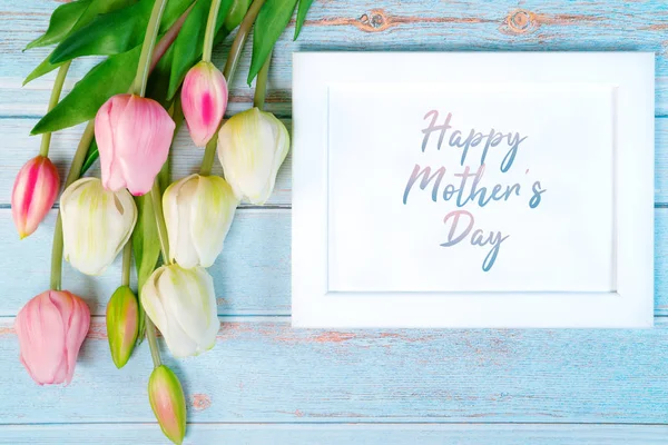 Feliz concepto del día de la madre. marco de imagen blanco y flor sobre fondo de madera — Foto de Stock