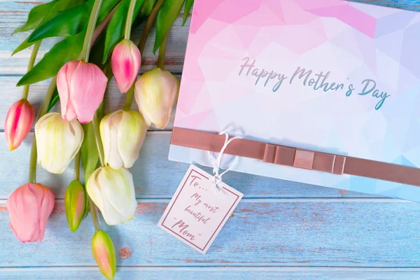 Feliz concepto del día de la madre. Caja de regalo y flor, etiqueta de papel — Foto de Stock