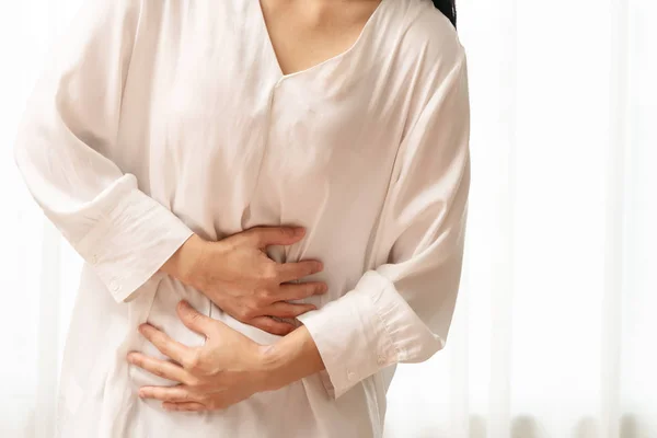 Ung kvinna som lider av buksmärta känsla magont, symptom på pms på vit bakgrund — Stockfoto