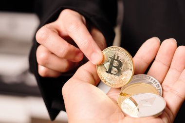 Şifreli para birimi Bitcoin. Kadınlar şifreli parayı elinde tutarlar. Fiziksel bitcoins altın sikke