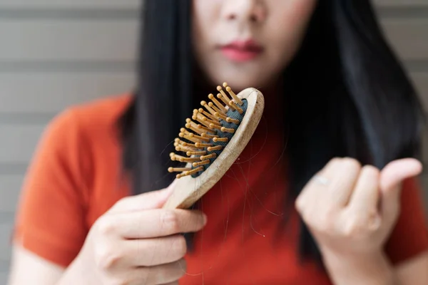 Long loss hair on woman brush with and woman looking at her hair — Stock Photo, Image