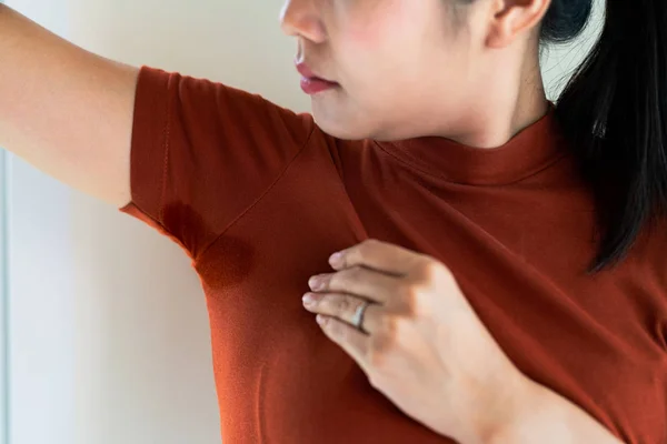 Женщина с гипергидрозом потеет. Молодая азиатка с пятном пота на нижнем белье. Концепция здравоохранения — стоковое фото