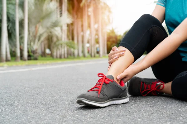 fitness woman runner feels pain on ankle leg. Outdoor exercise activities concept