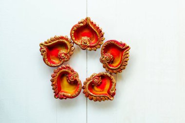 Mutlu Diwaliler - Dipavali sırasında Clay Diya lambaları yandı, Hindu ışık festivali kutlaması. Beyaz ahşap arka planda renkli geleneksel gaz lambası diya