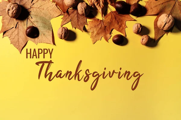黄色の背景にカエデの葉とナッツと幸せな感謝祭 — ストック写真