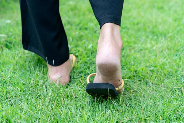 Dry heels feet of woman on grass