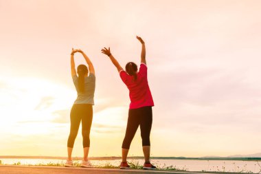 Spor kadınları antrenmandan önce kas esnetiyorlar.