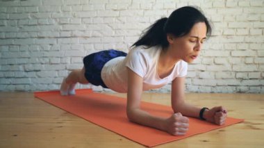 Genç ince ve güzel kadının yapması spor plank. Spor ve sağlıklı yaşam kavramı