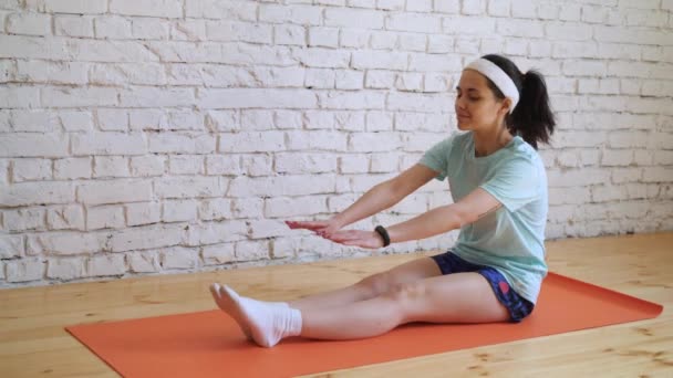 Beautiful young girl doing exercises at home — Stock Video