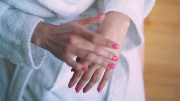 Una giovane ragazza, una casalinga con i bigodini, che si prende cura della pelle delle mani. Beauty Spa ritratto donna con pelle perfetta. bella bruna — Video Stock