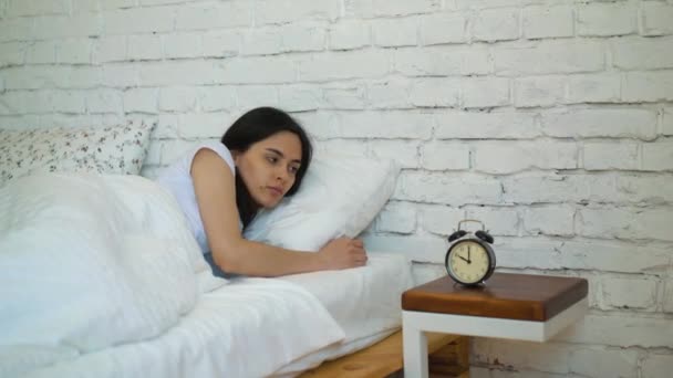 Morena cansada desligando seu despertador em seu quarto . — Vídeo de Stock