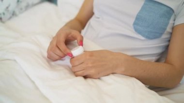 Kız can elinden hapları koyar. Doğum kontrol hapı yemek.