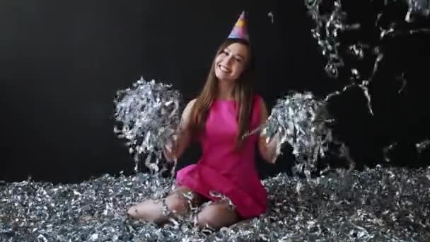 Jovem feliz em vestido rosa celebra Ano Novo ou aniversário em fundo preto com confete — Vídeo de Stock