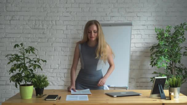 Jonge mooie zakenvrouw zitten aan de tafel met laptop. — Stockvideo